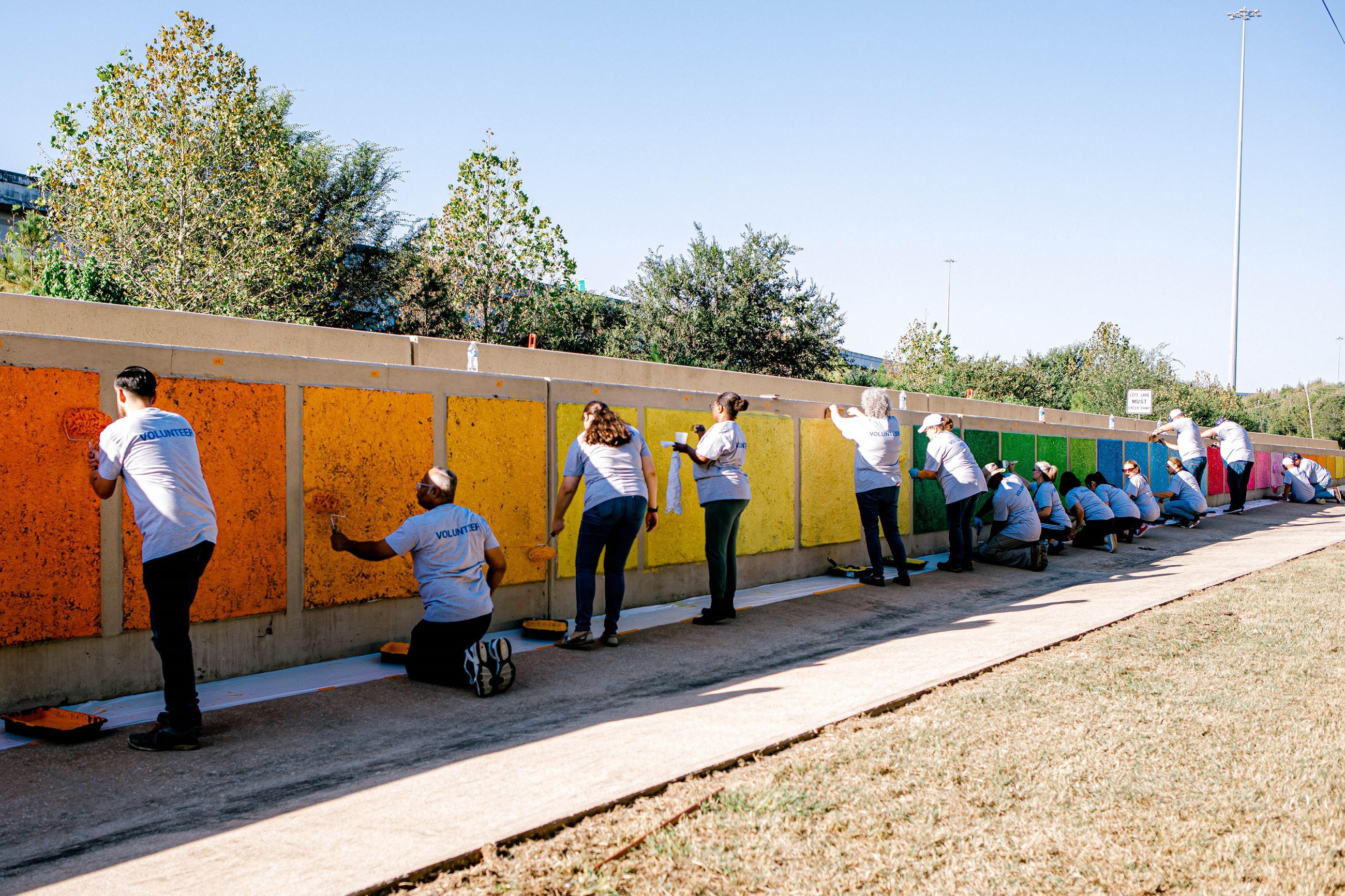 People painting bright colors to a wall