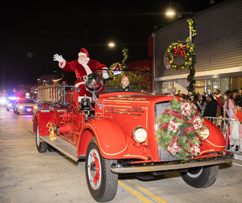 Santa Clause riding a red car at the Christmas Parade